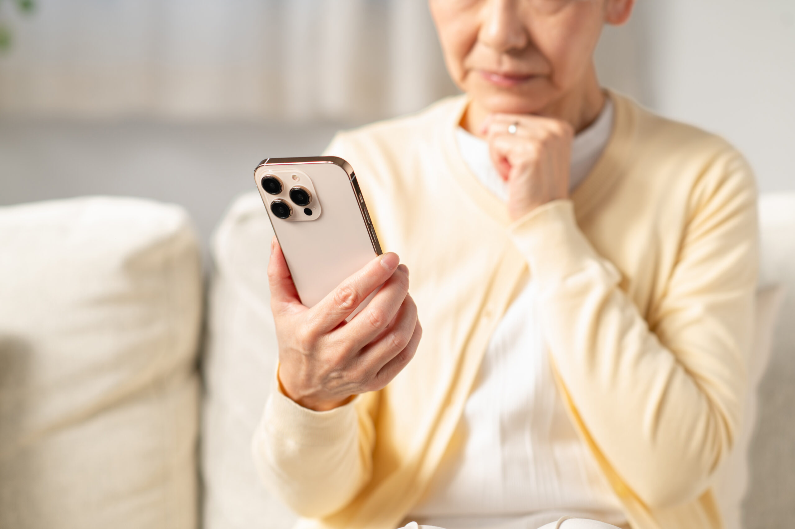 リビングでスマホを使うシニアの日本人女性(パーツ) 悩む高齢者2